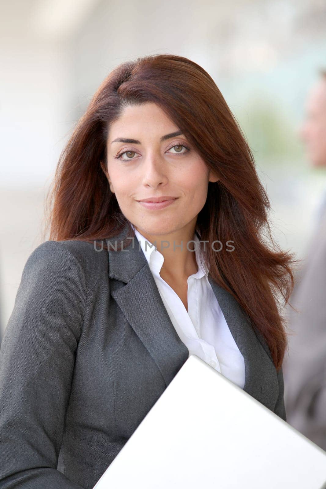 Businesswoman with laptop computer standing outside