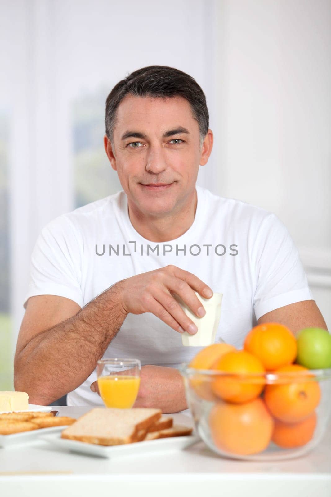 Smiling adult man having breakfast