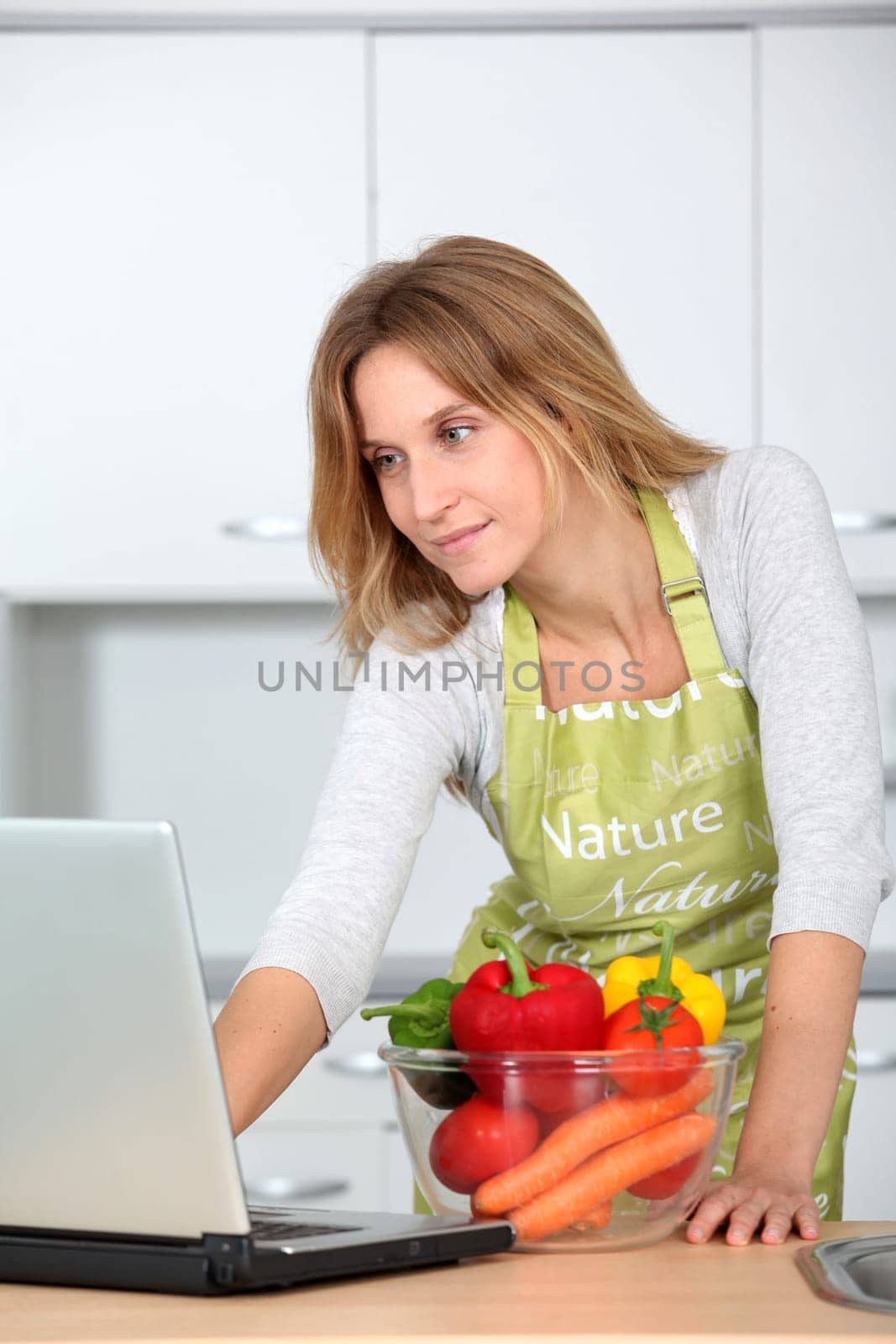 Woman in kitchen looking for cooking receipe