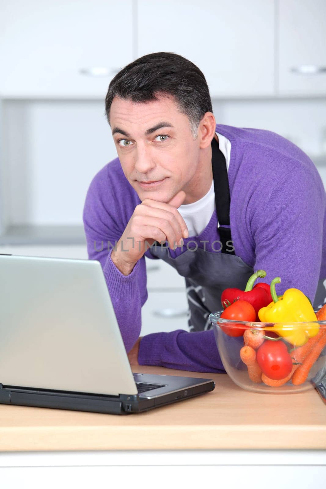 Man in kitchen with laptop computer
