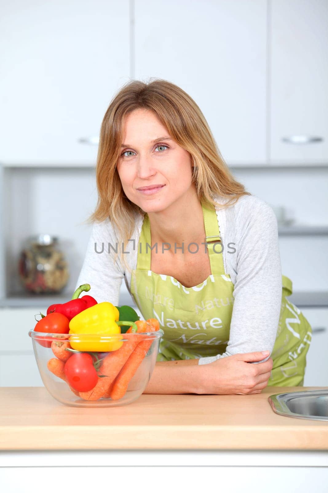 Woman in kitchen ready to prepare meal with vegetables