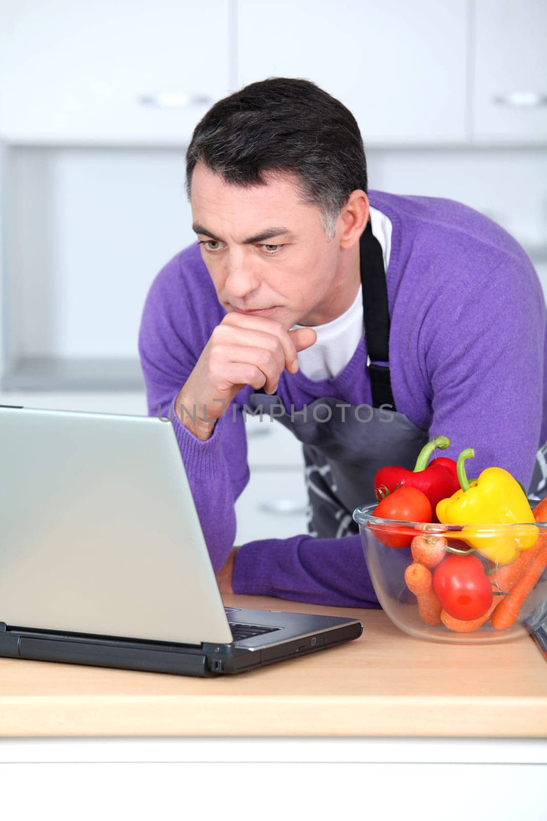 Man in kitchen with laptop computer