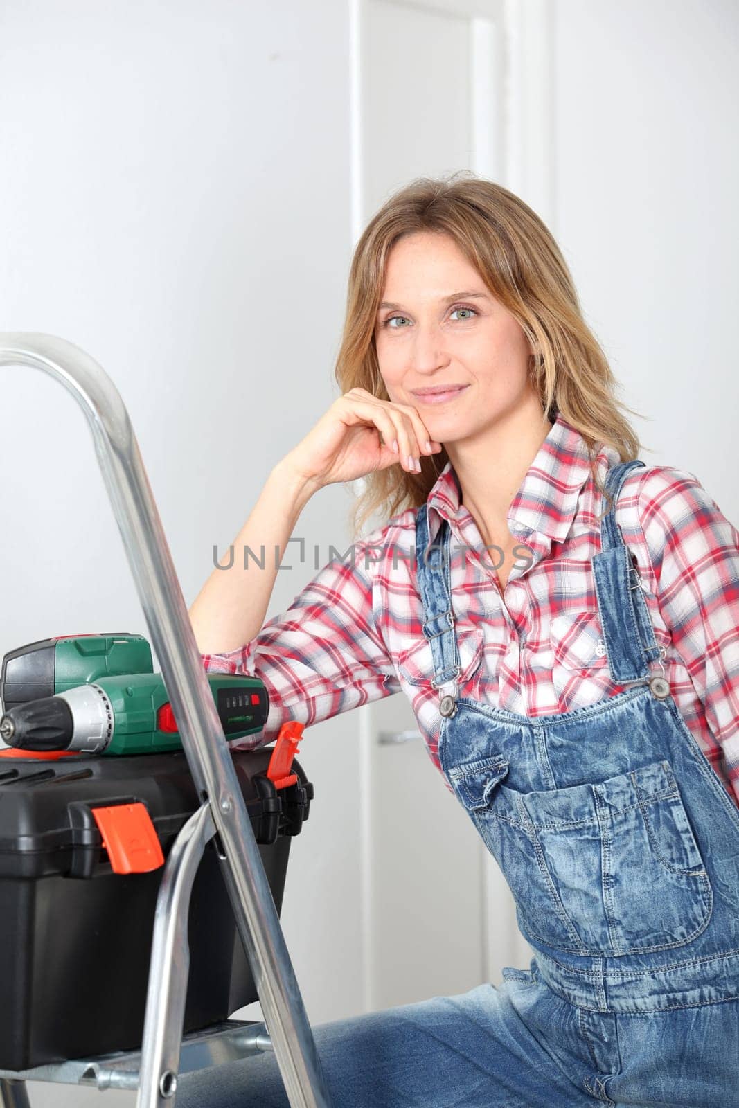Woman using electric drill at home