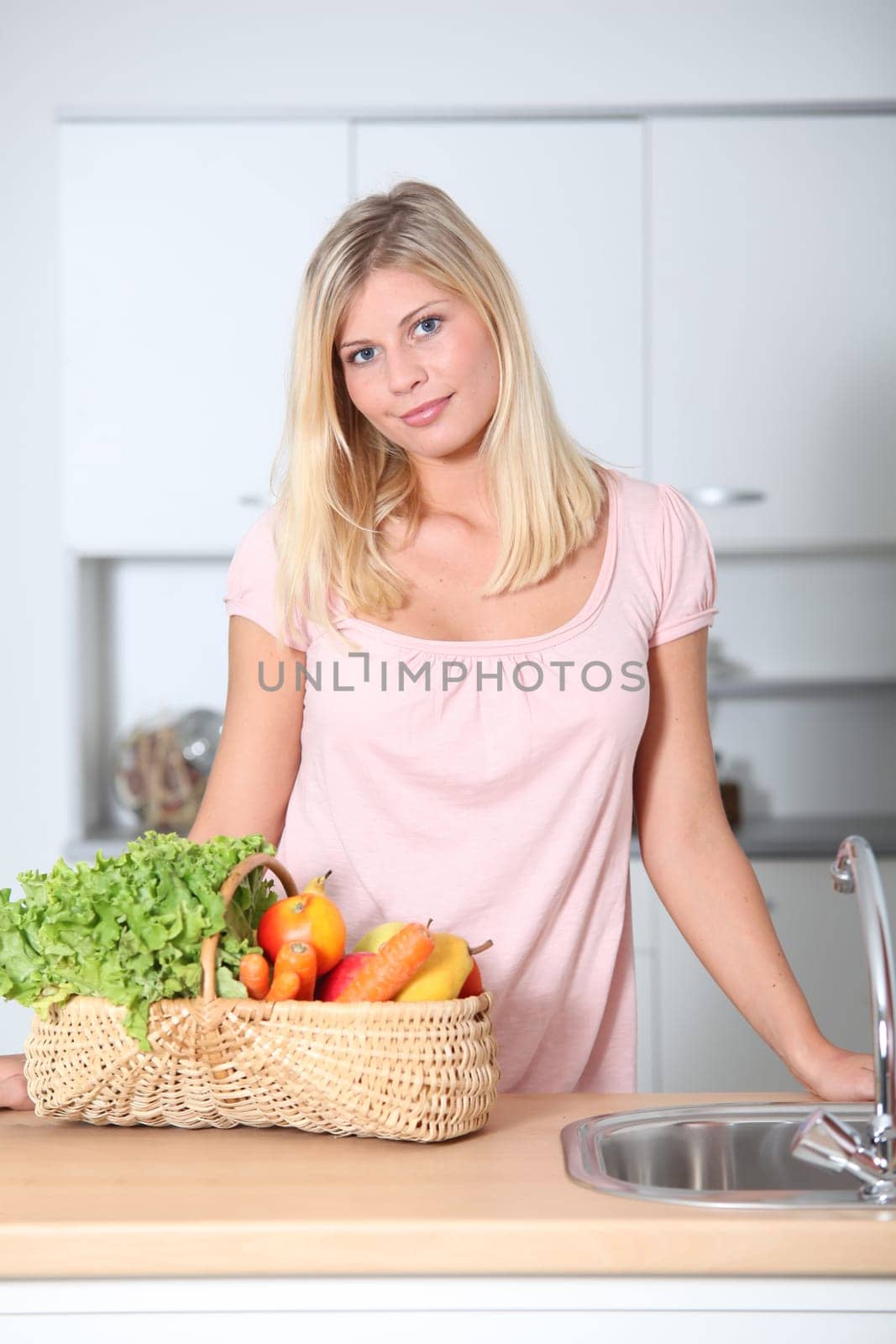 Smiling woman holding basket of organic food