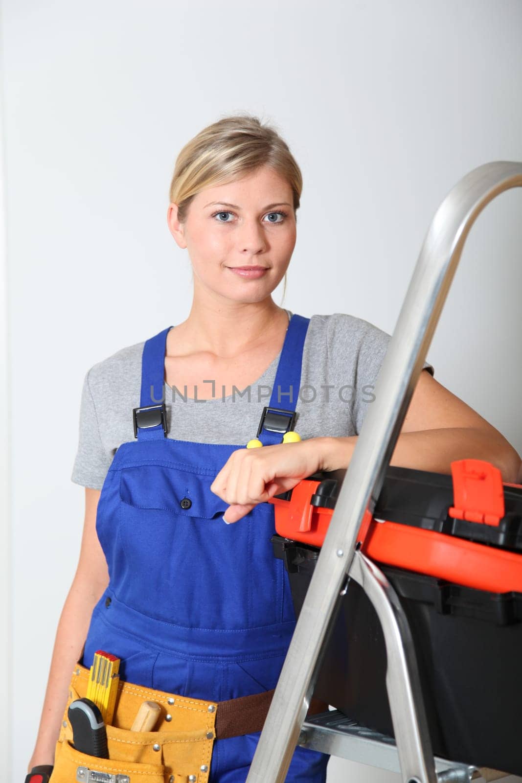 Smiling electrician woman standing by scale