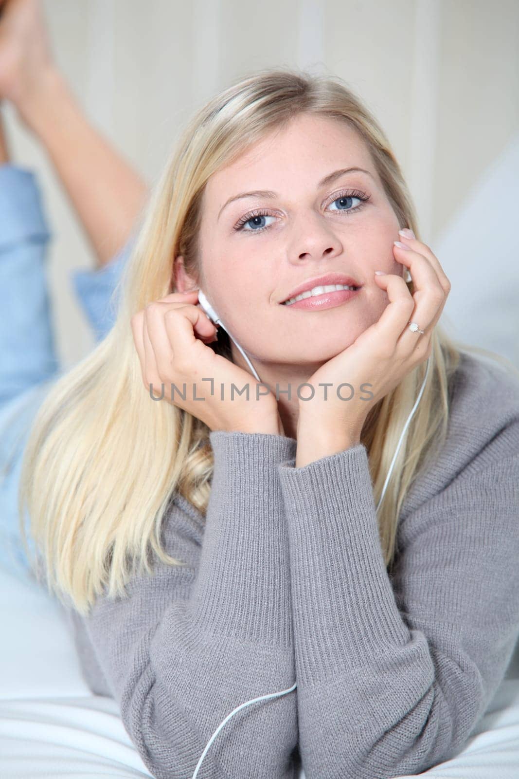 Beautiful blond woman at home with headphones on