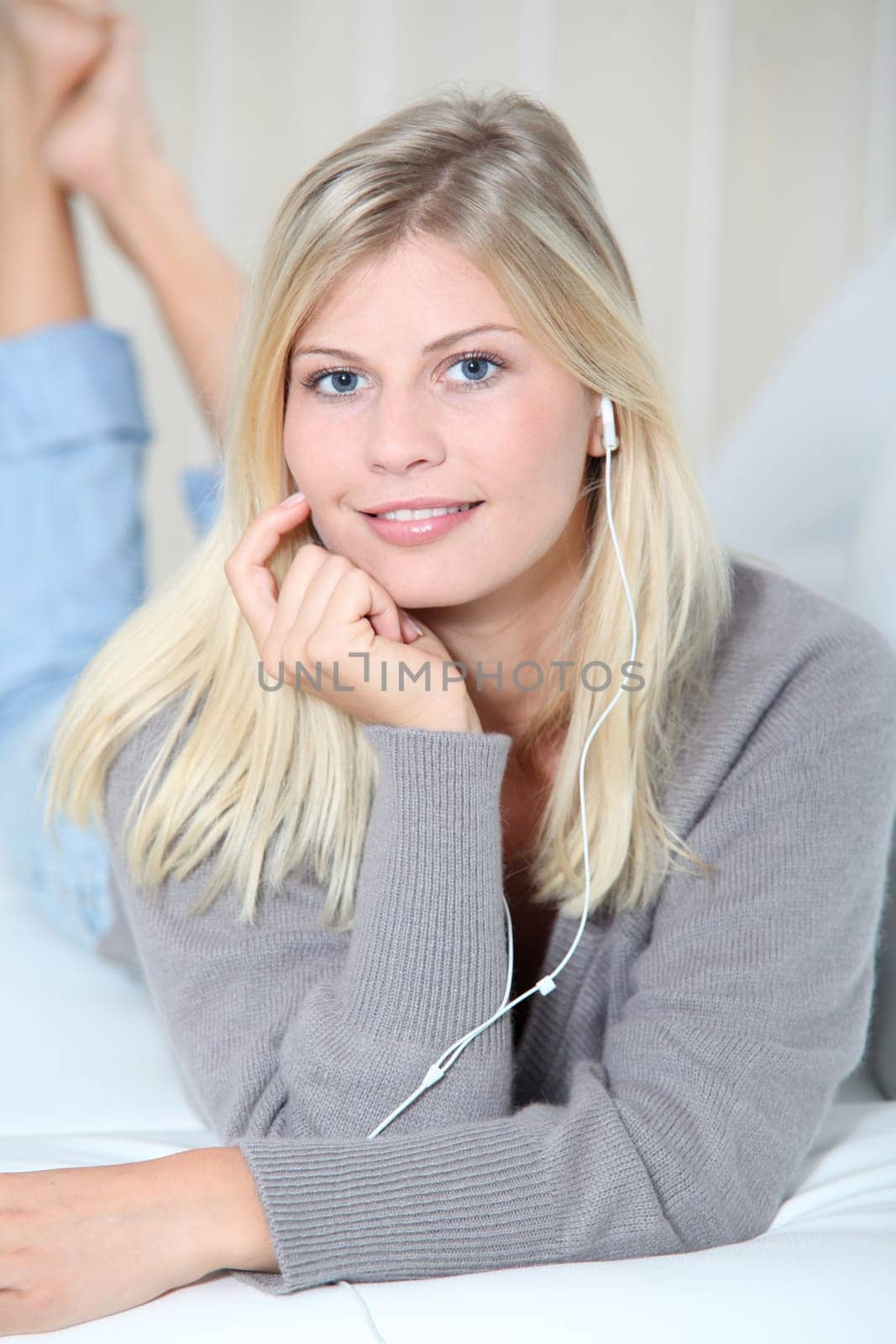 Beautiful blond woman at home with headphones on