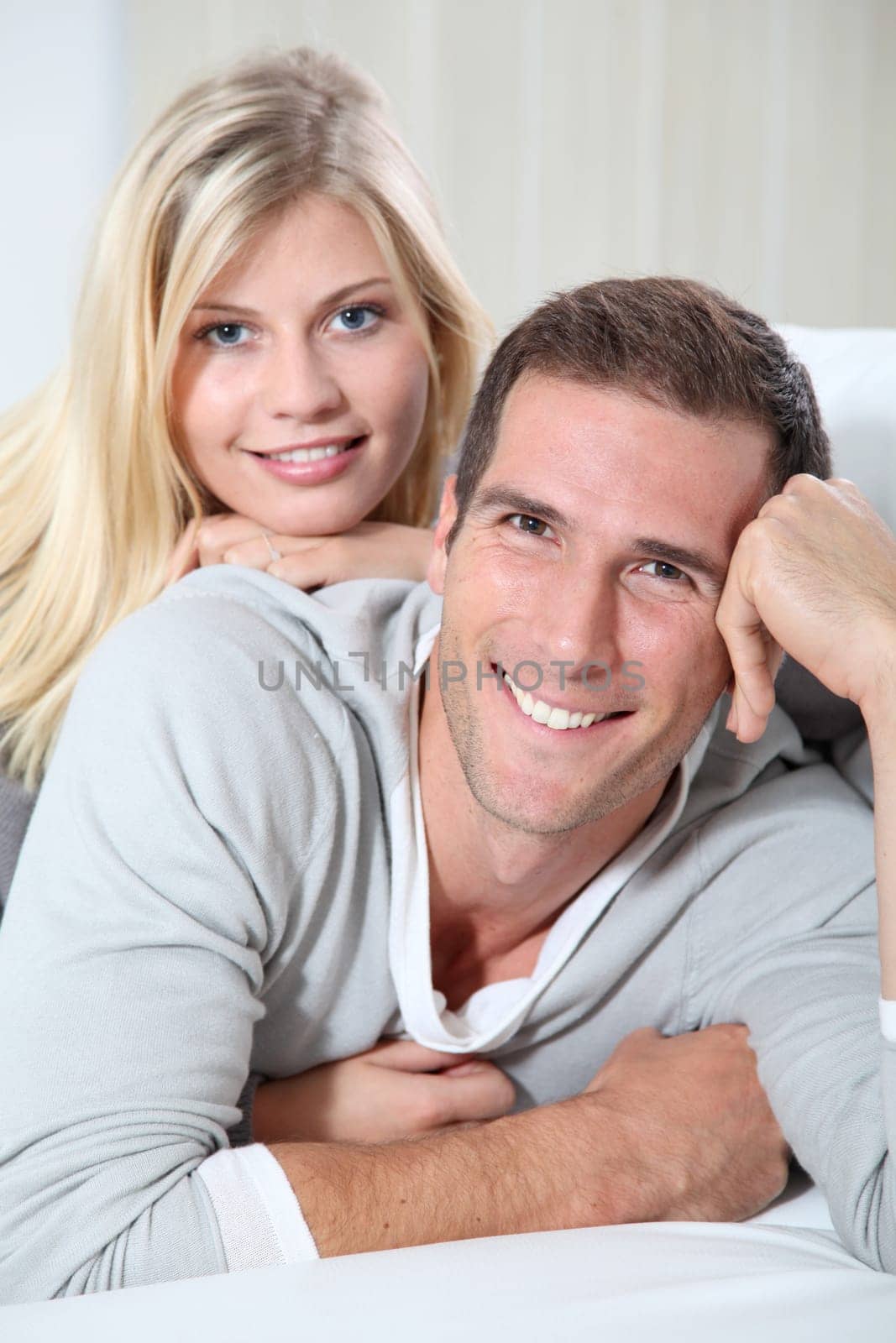 Smiling couple laying on sofa