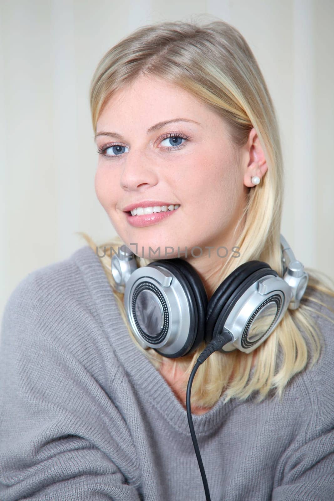 Beautiful blond woman at home with headphones on