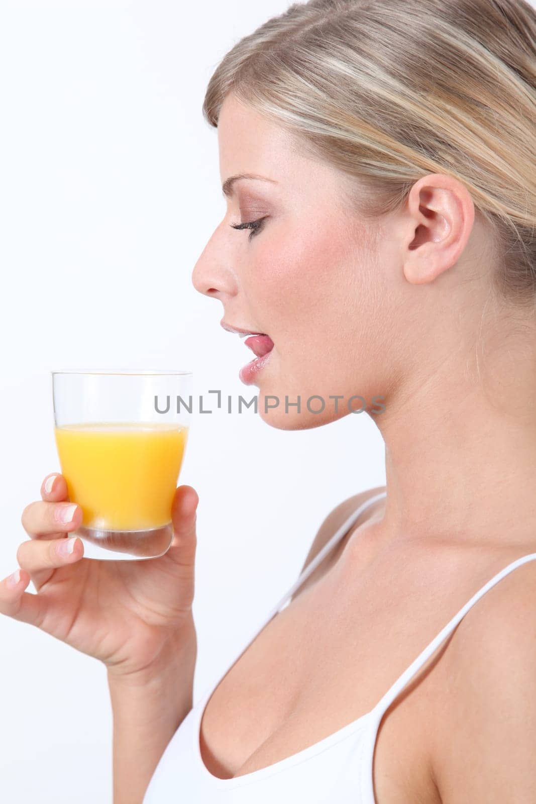 Beautiful blond woman holding glass of orange juice