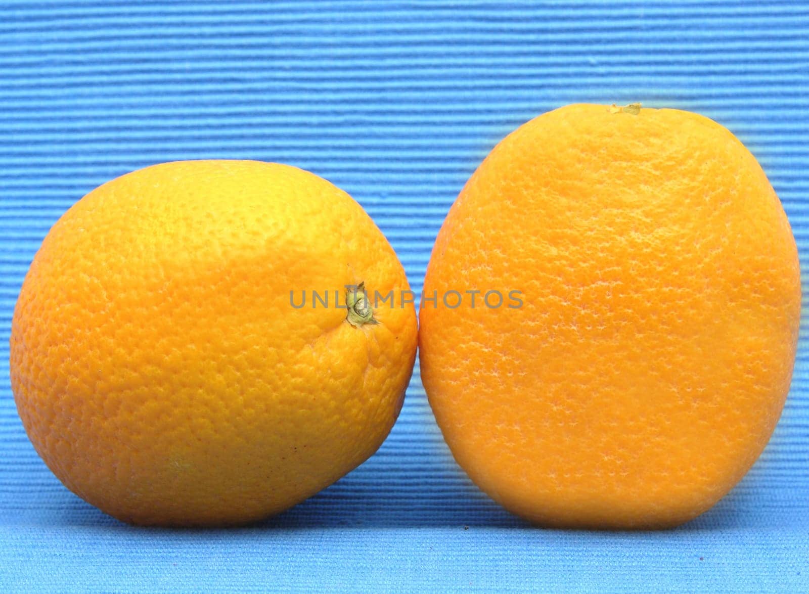Two oranges against blue background