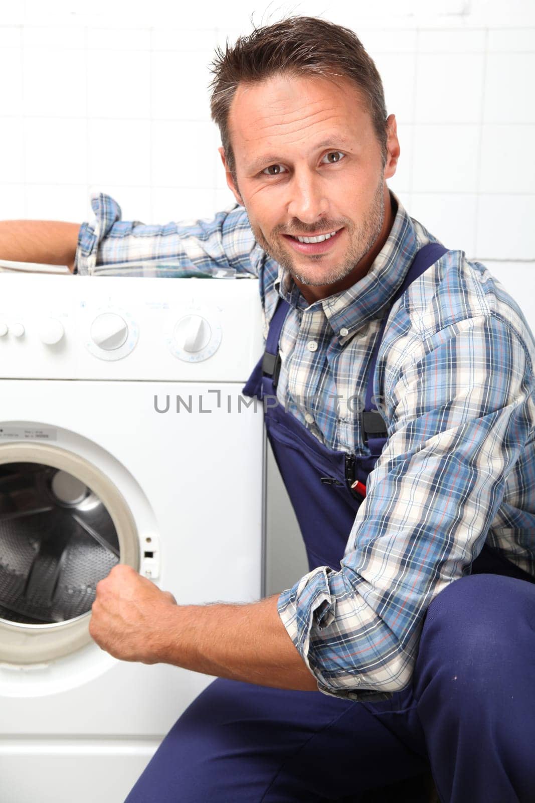 Plumber fixing broken washing machine