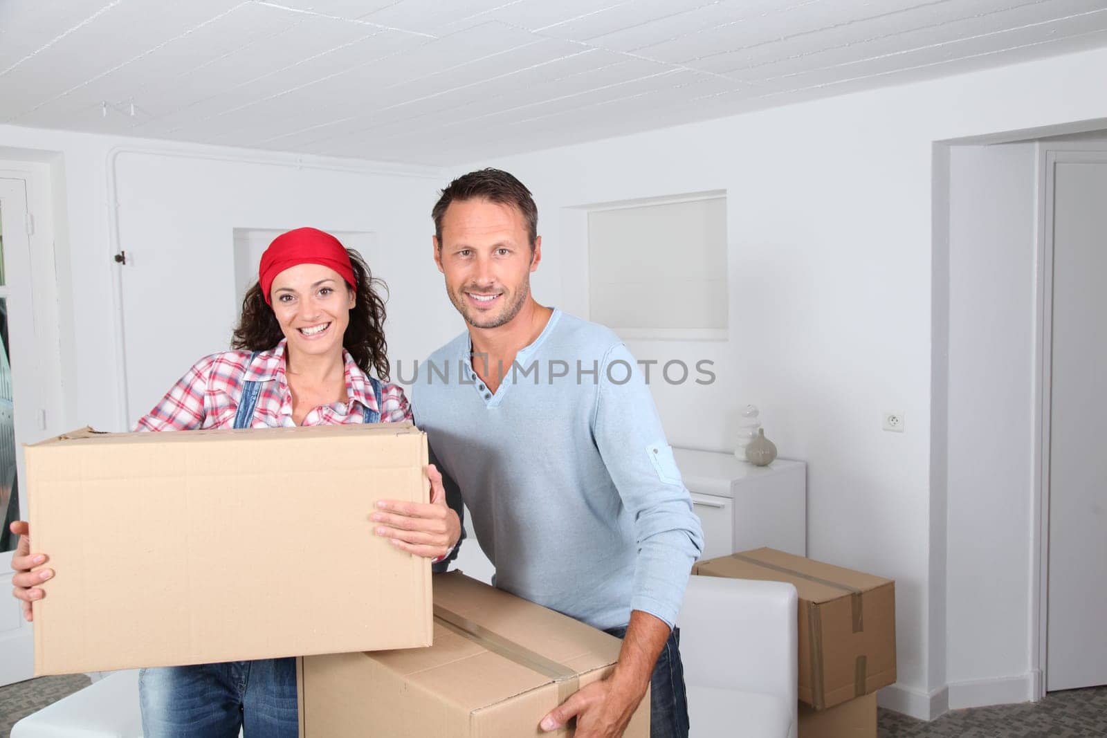 Couple holding boxes in their new home