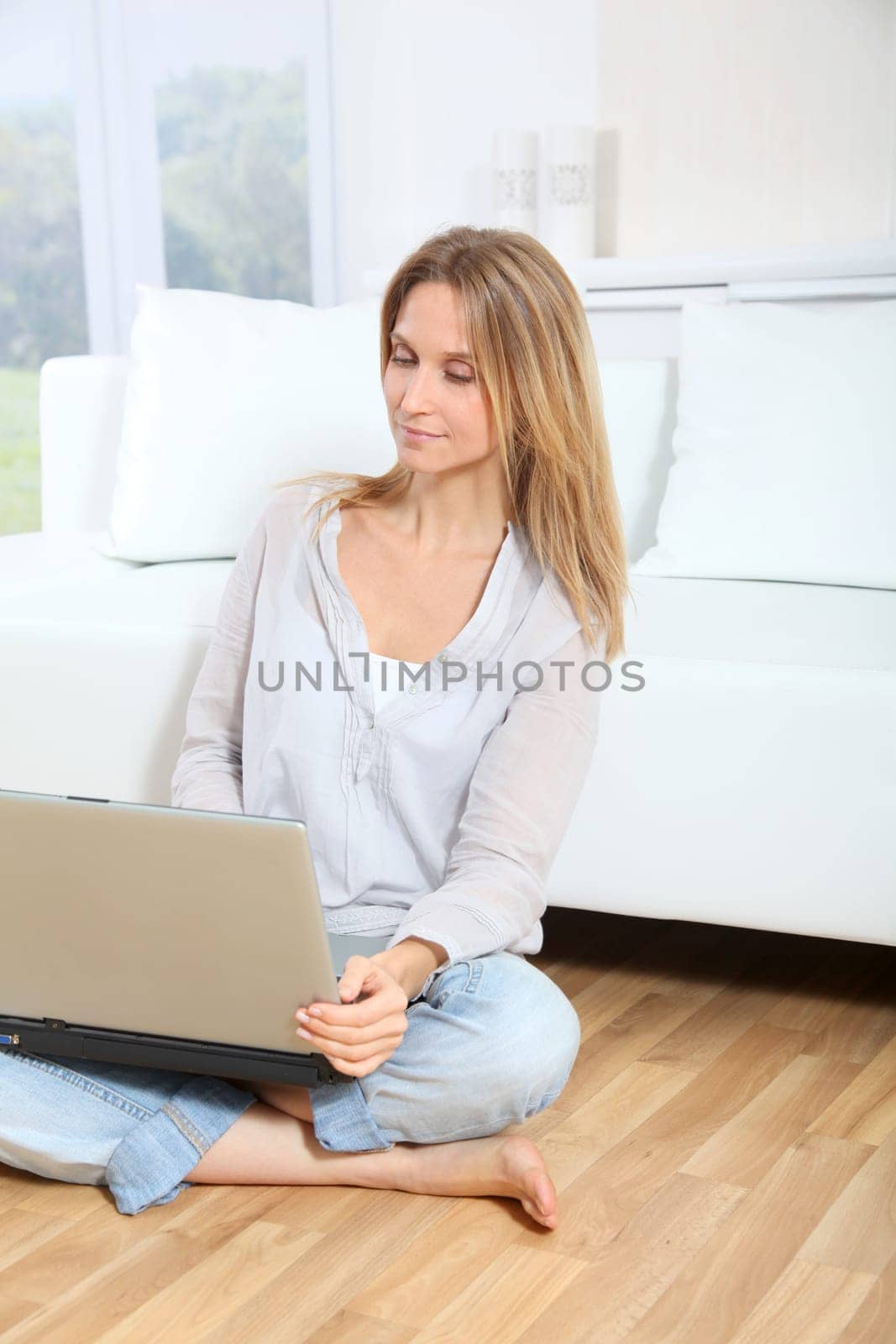 Beautiful blond woman surfing on internet at home