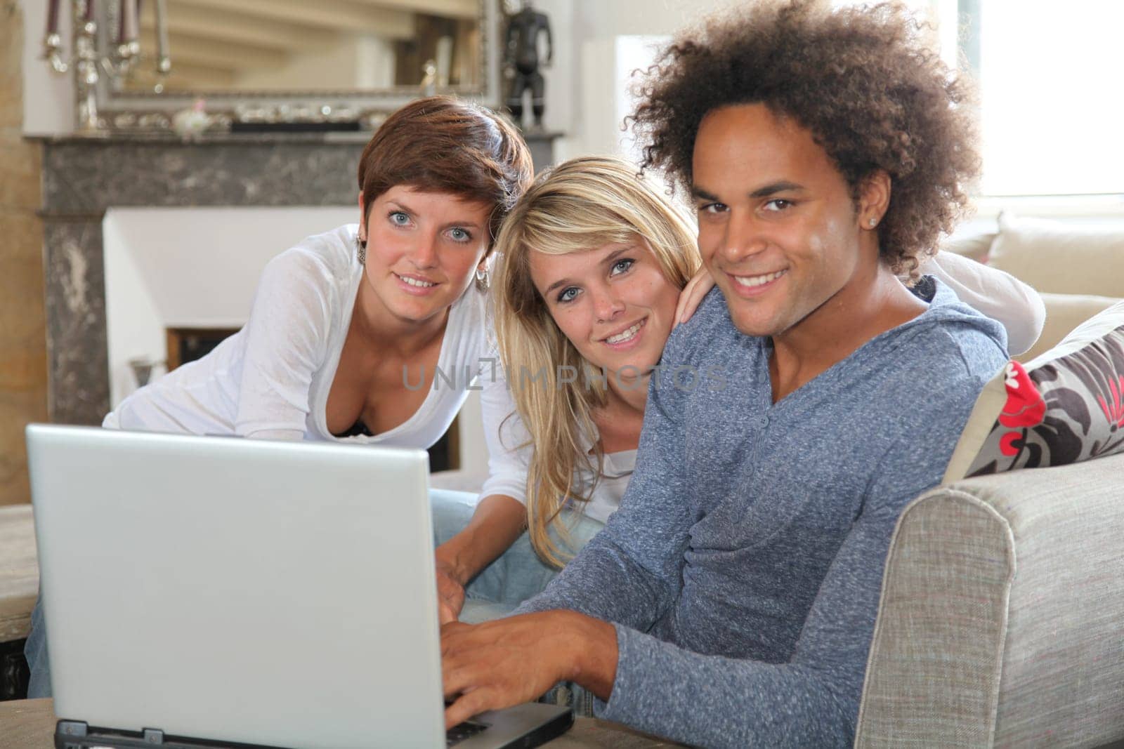 Group of friends sitting in sofa with laptop computer