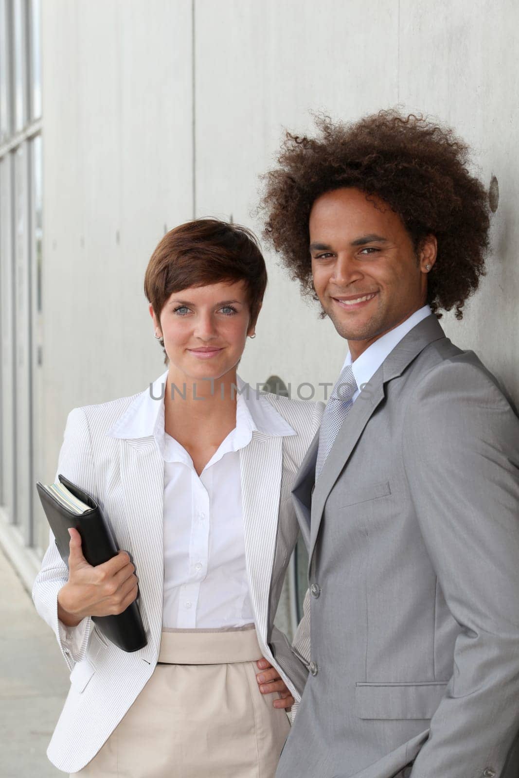 Business people standing against a wall