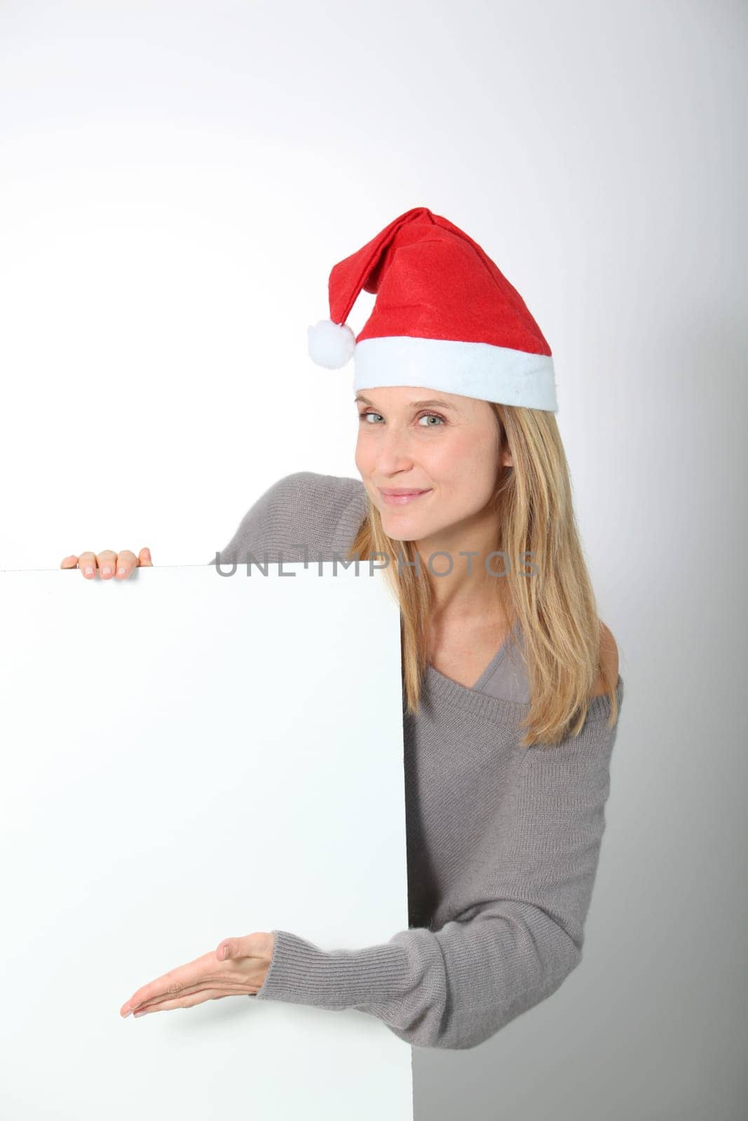 Blond woman with Santa hat showing white board