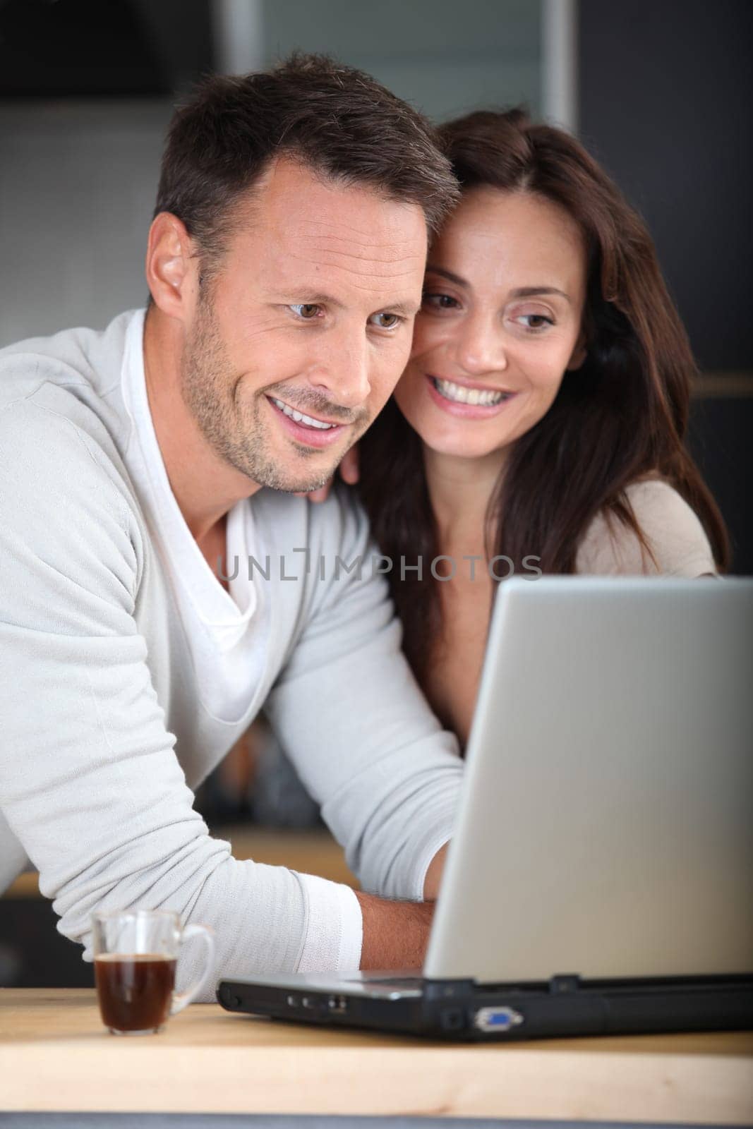 Couple at home connected on internet with laptop computer
