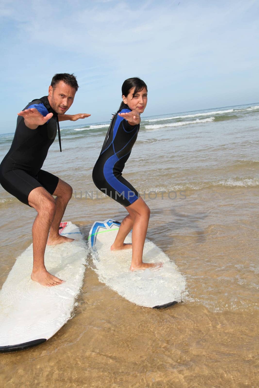 Father and daughter surfing in the ocean
