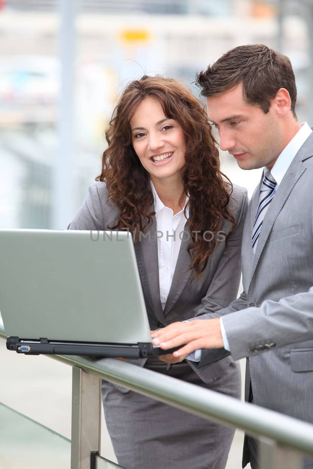 Business people working on laptop computer outside