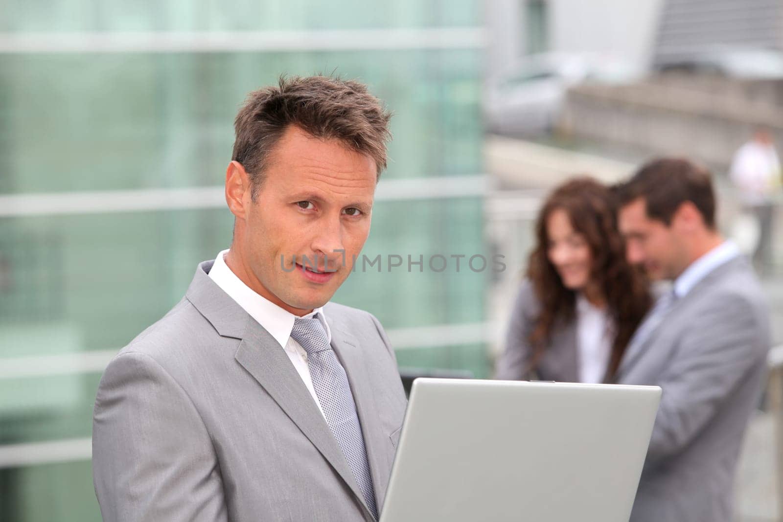 Businessman standing in front of offices outside