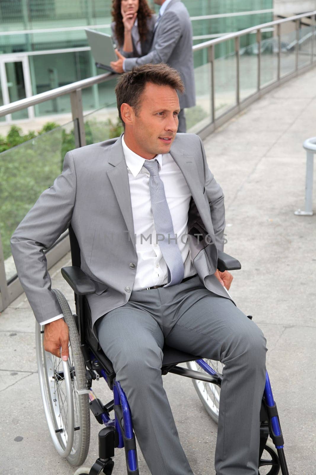 Businessman in wheelchair waiting for a taxi