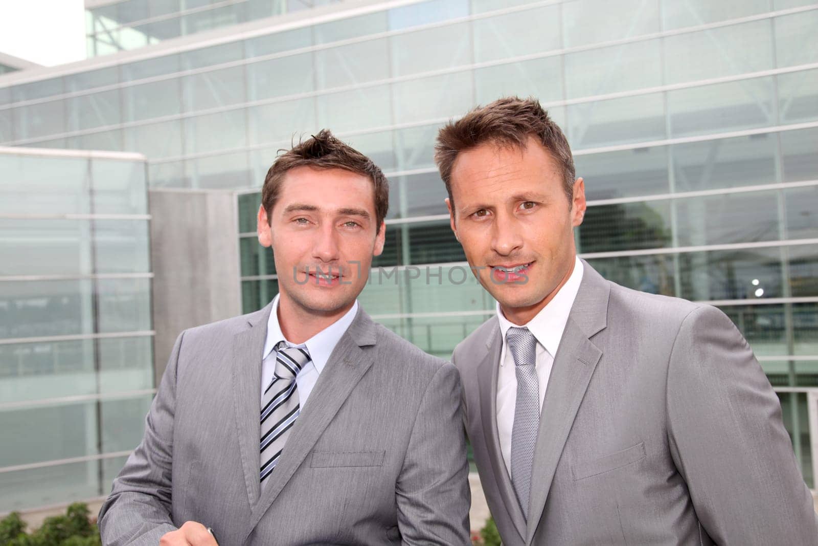 Portrait of businessmen standing in front of modern building