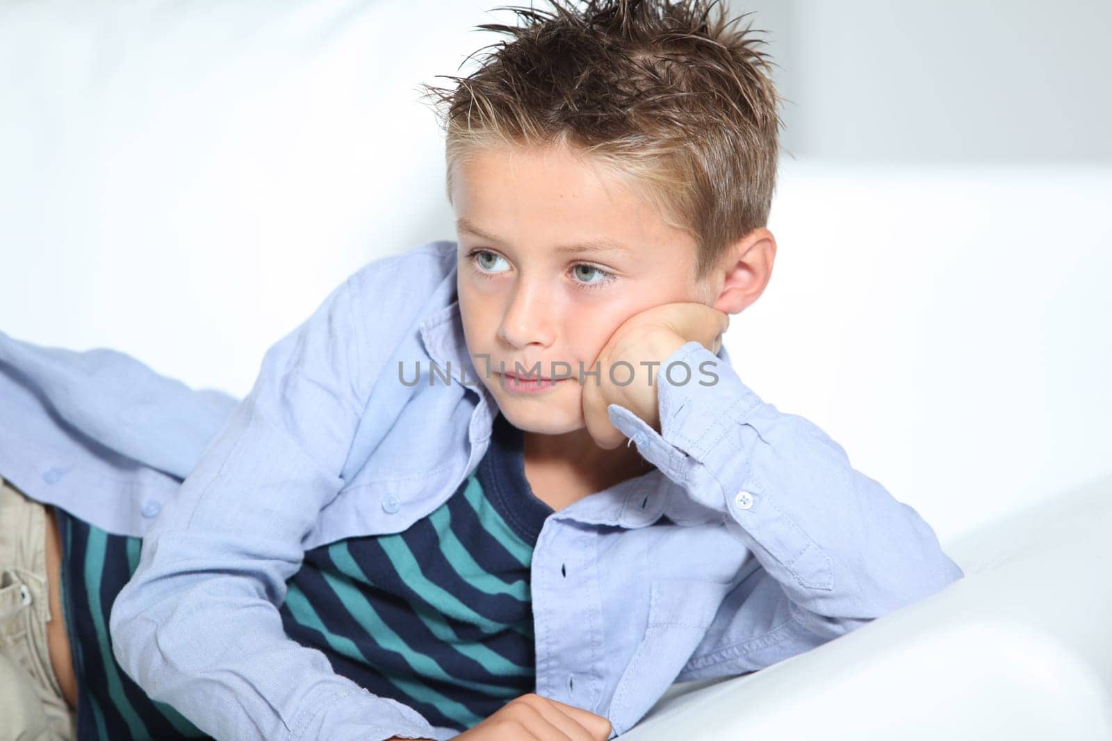 Young boy laying on a sofa at home