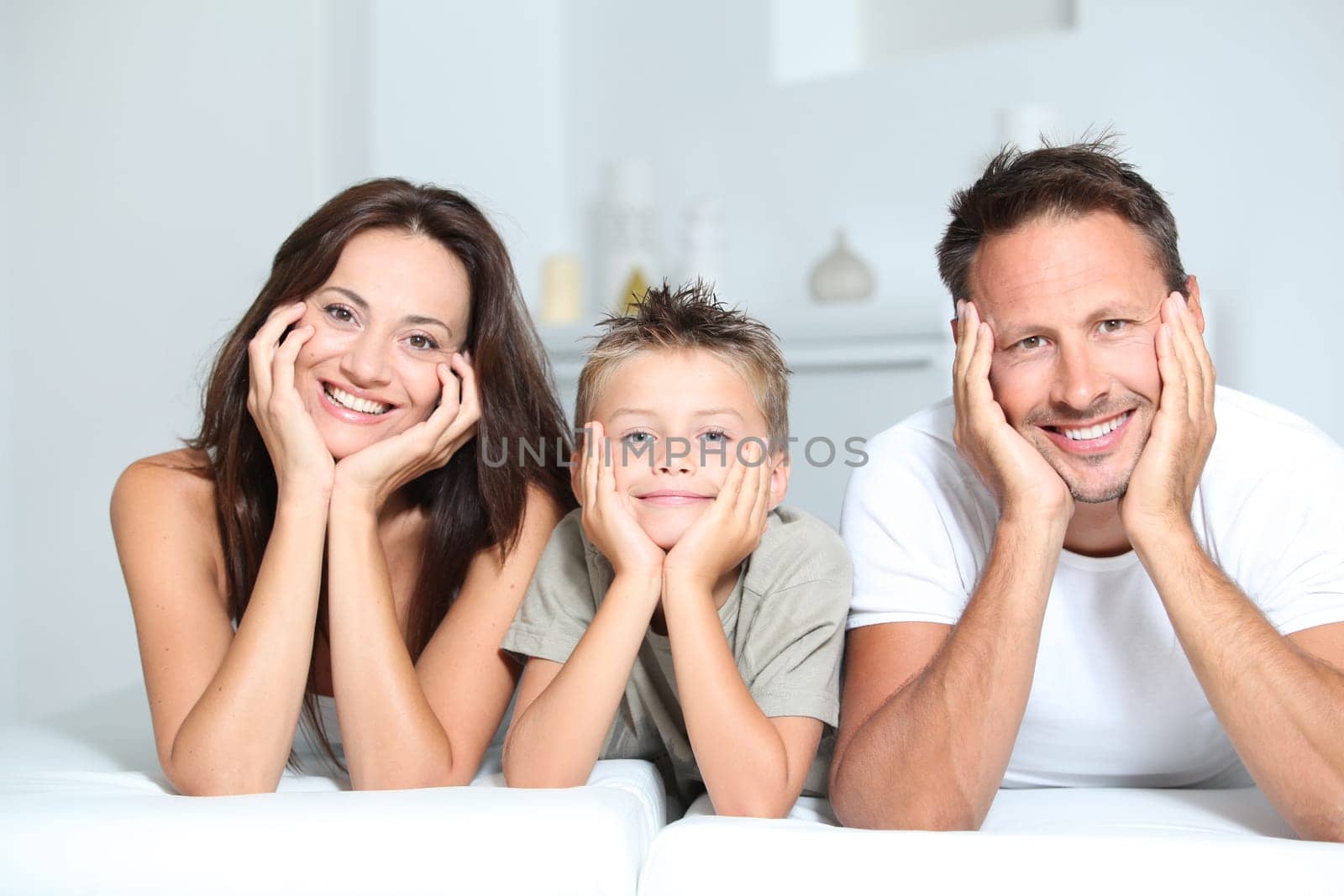 Closeup of parents and child relaxing at home on sofa