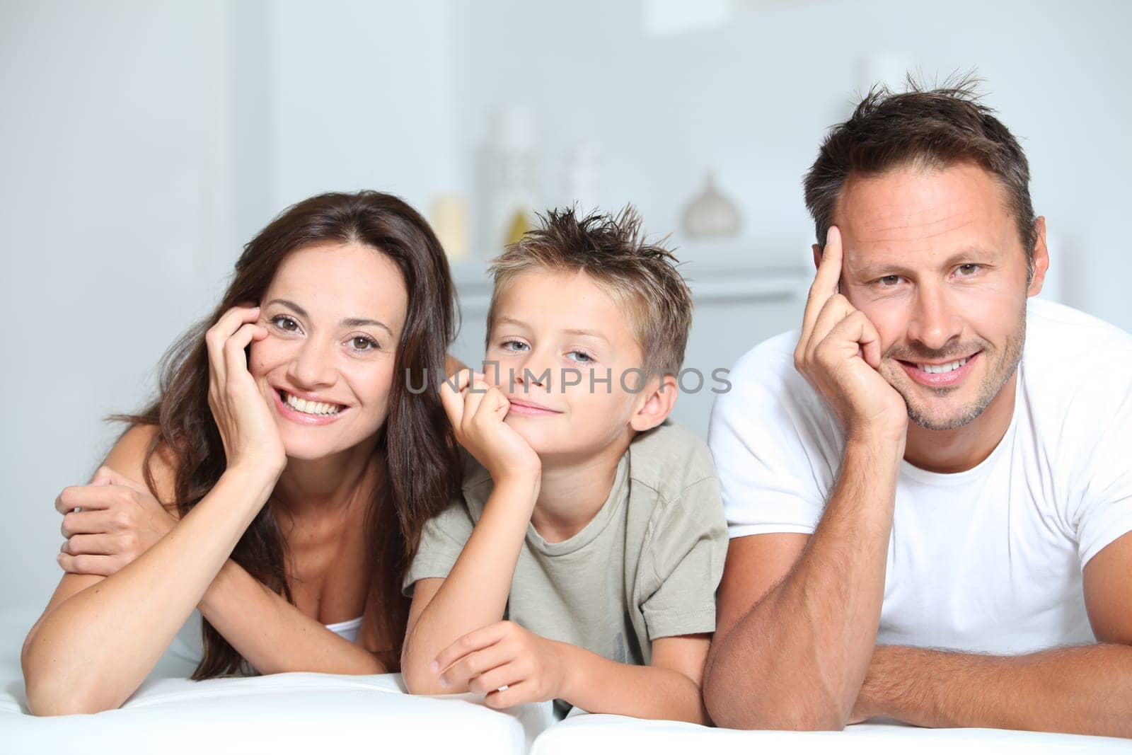Closeup of parents and child relaxing at home on sofa