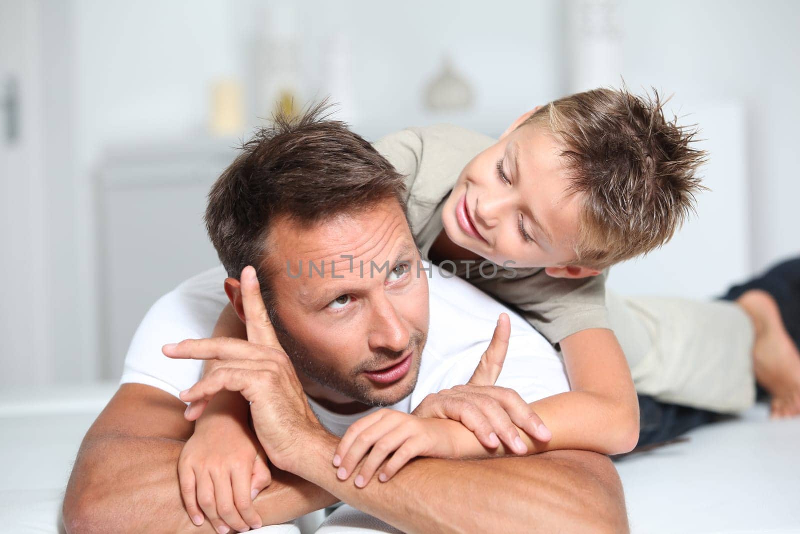 Father and son playing on sofa