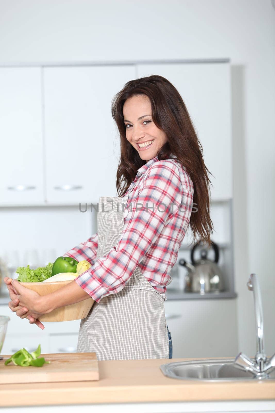 Beautiful woman stading in kitchen with apron