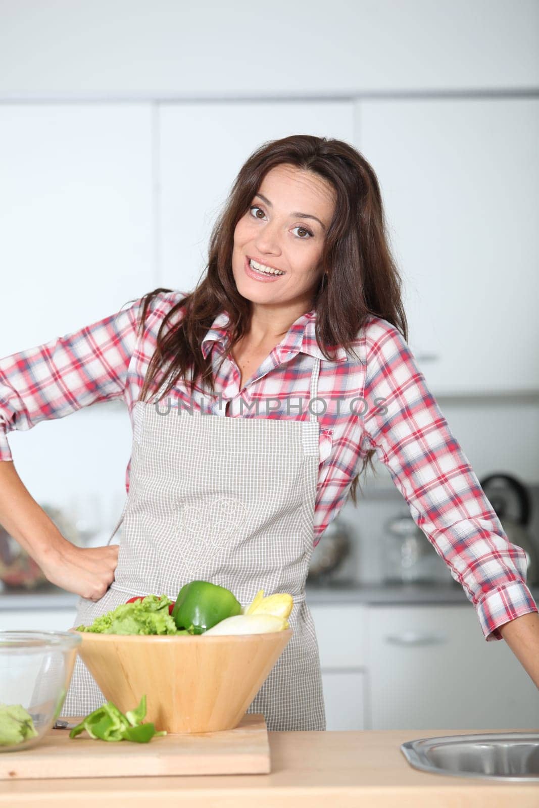 Beautiful woman stading in kitchen with apron