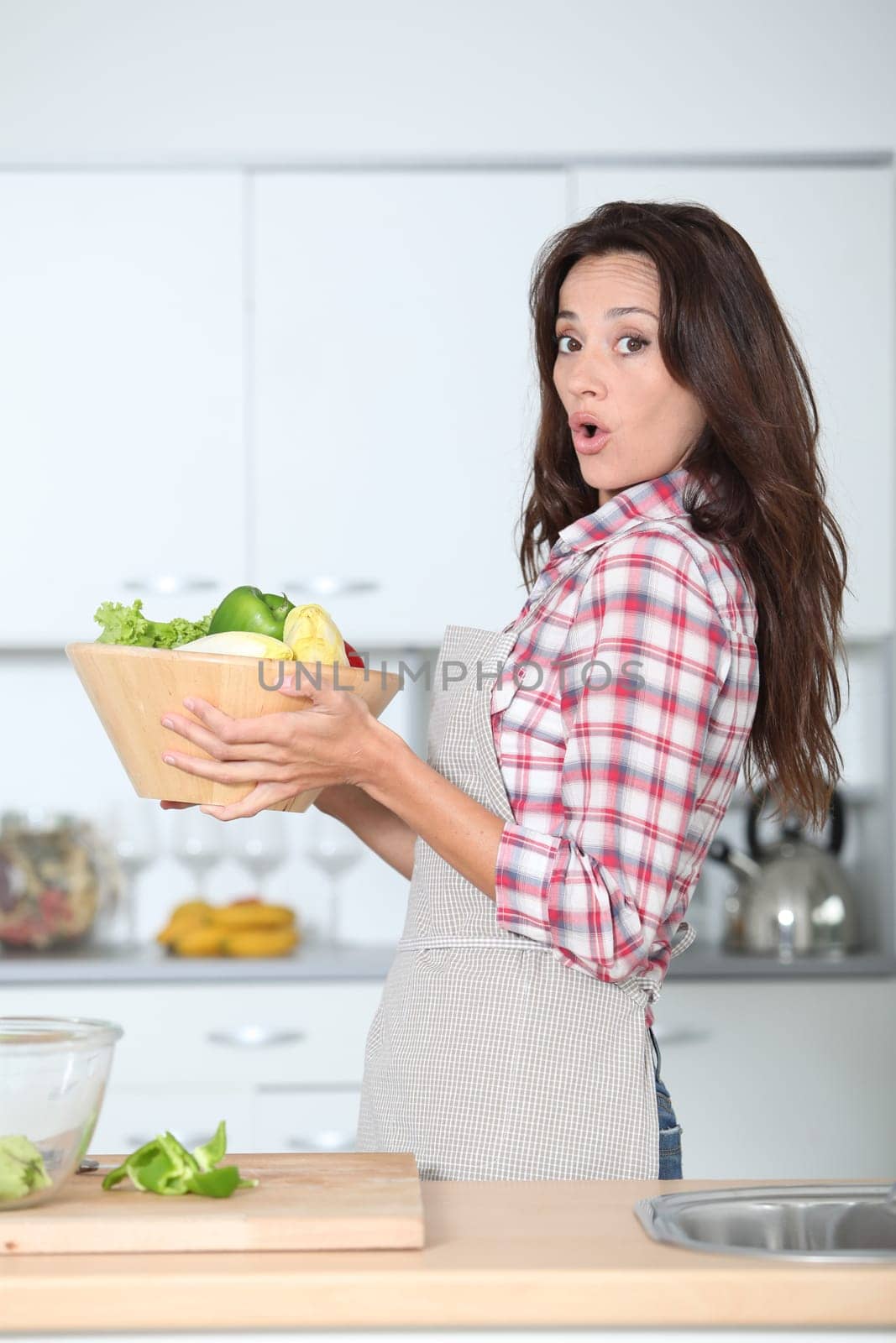 Beautiful woman stading in kitchen with apron