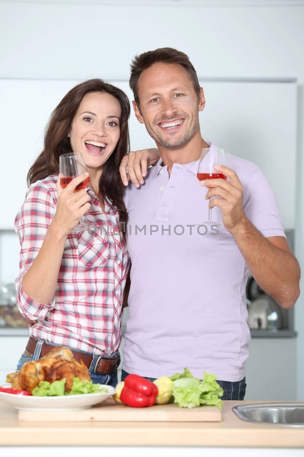 Couple drinking wine while fixing dinner