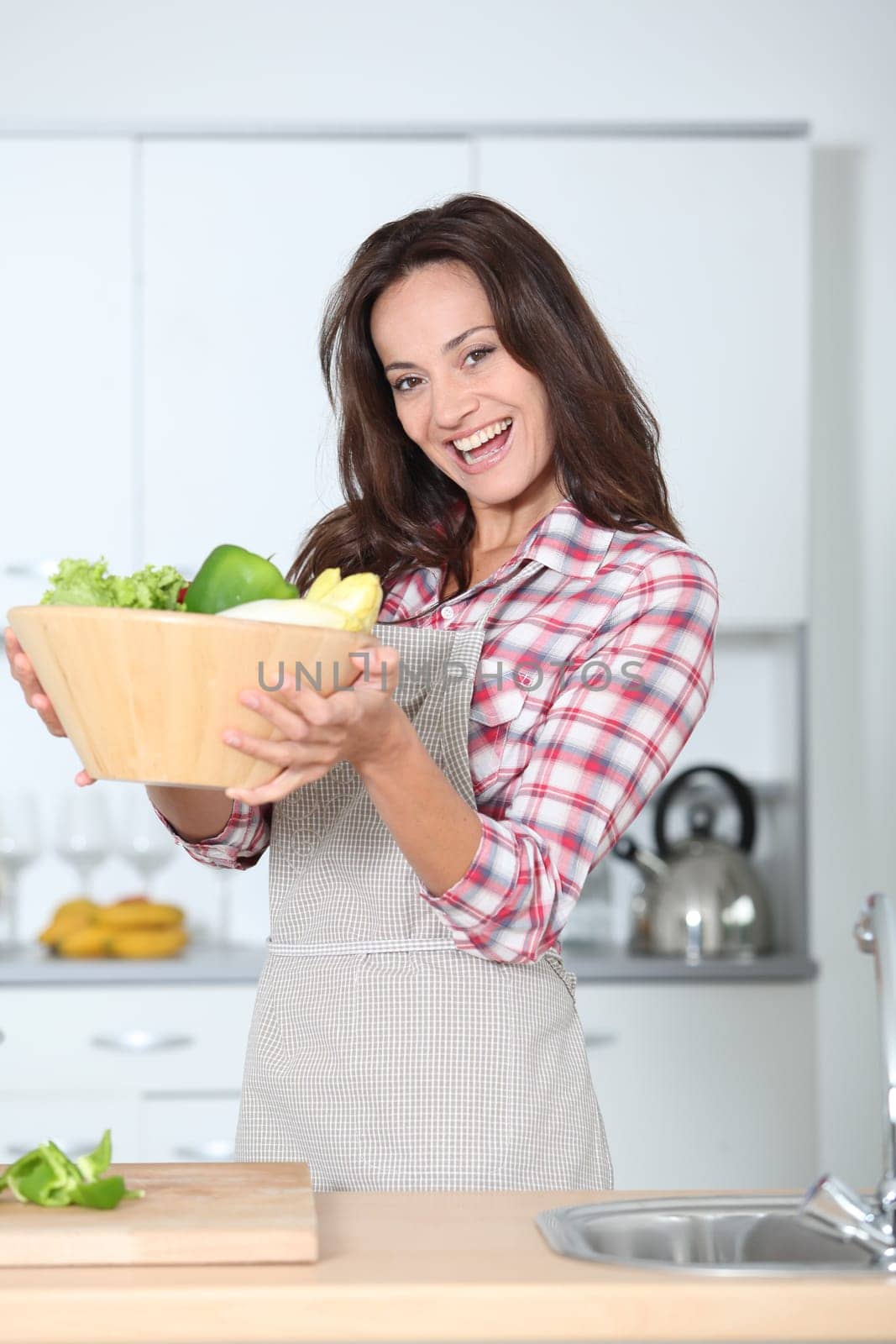 Beautiful woman stading in kitchen with apron