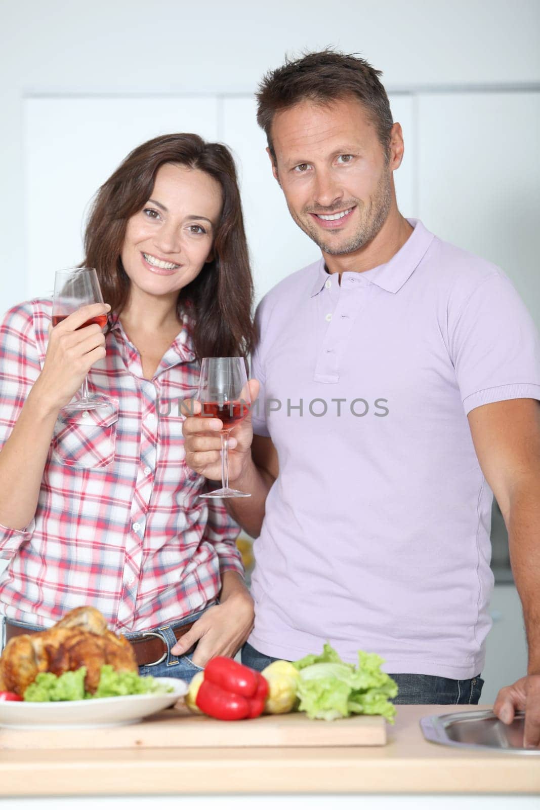 Couple drinking wine while fixing dinner