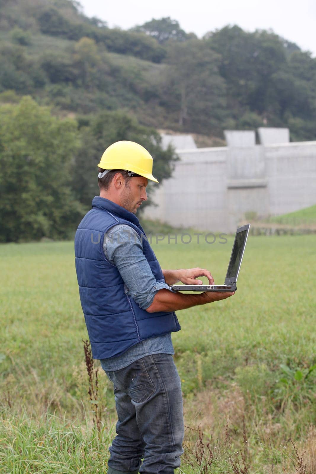 Engineer standing in front of dam under construction