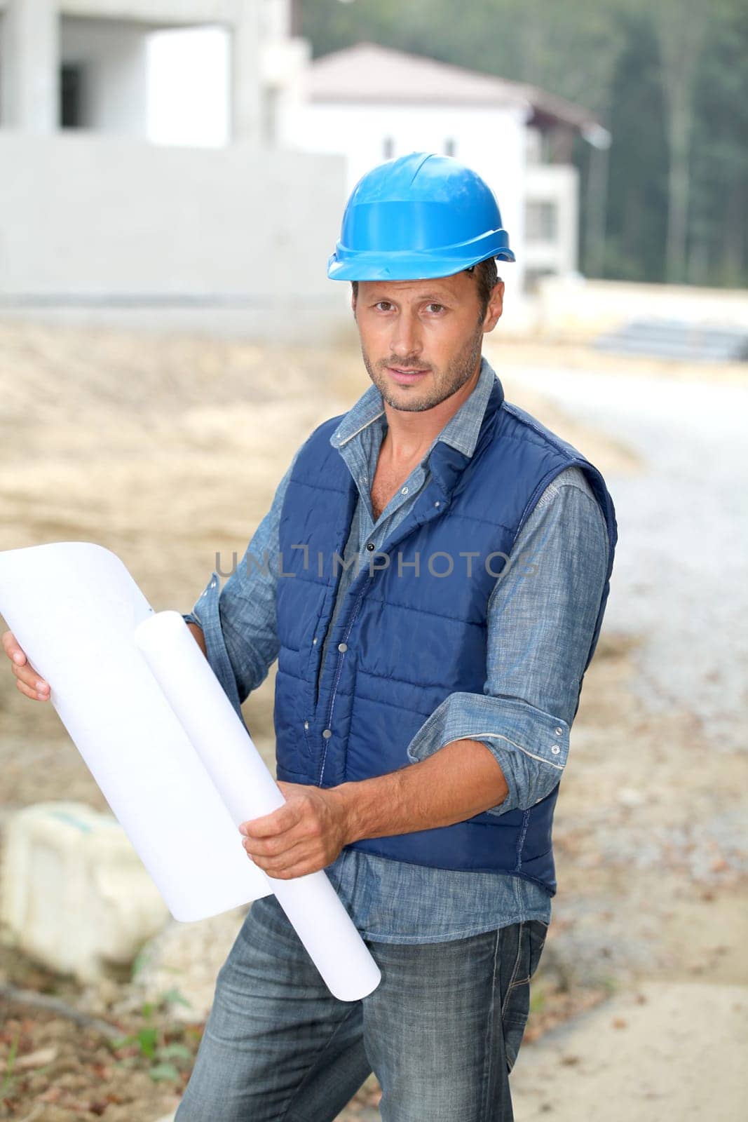 Businessman with helmet checking site under construction