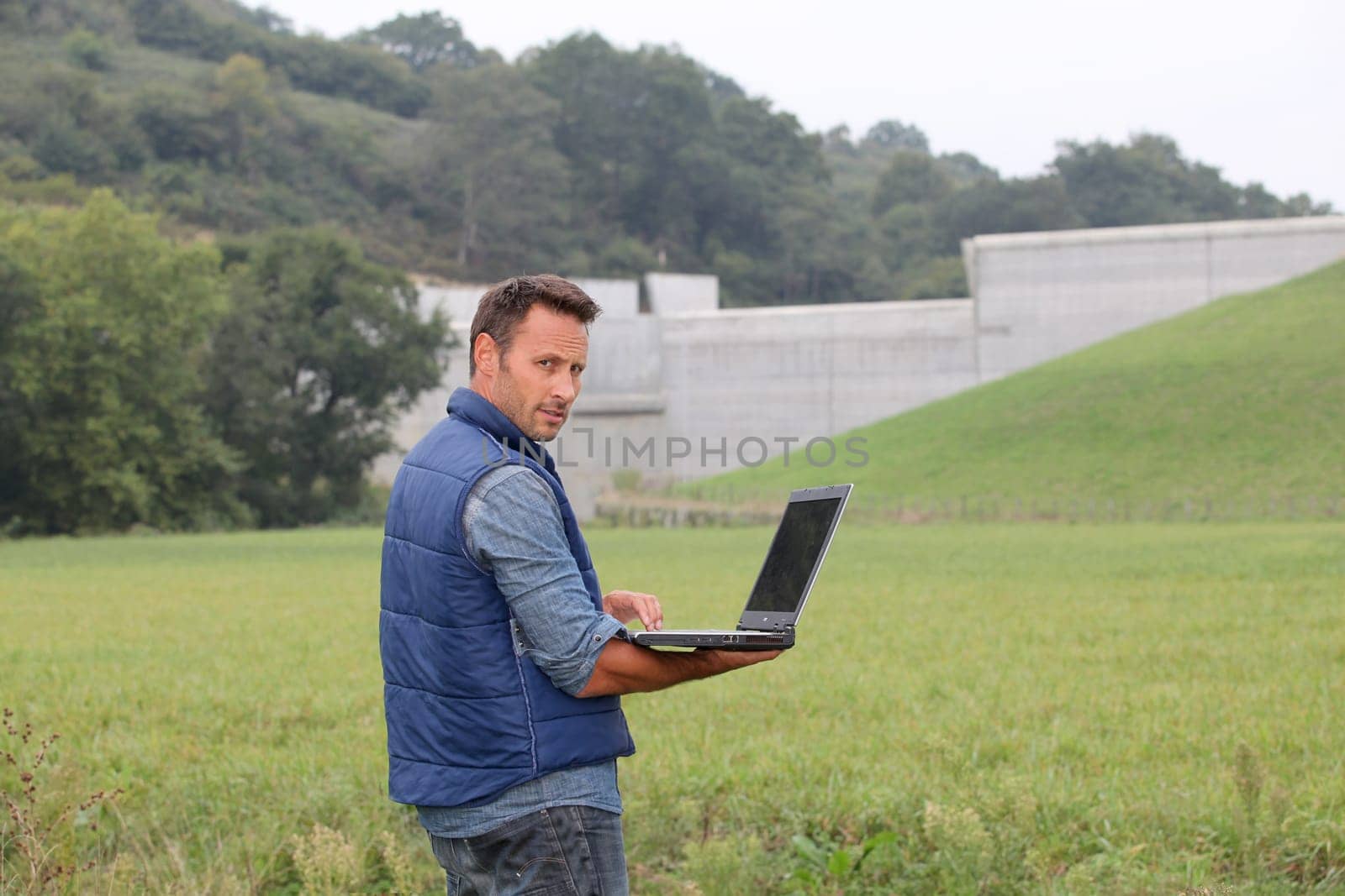 Engineer standing in front of dam under construction