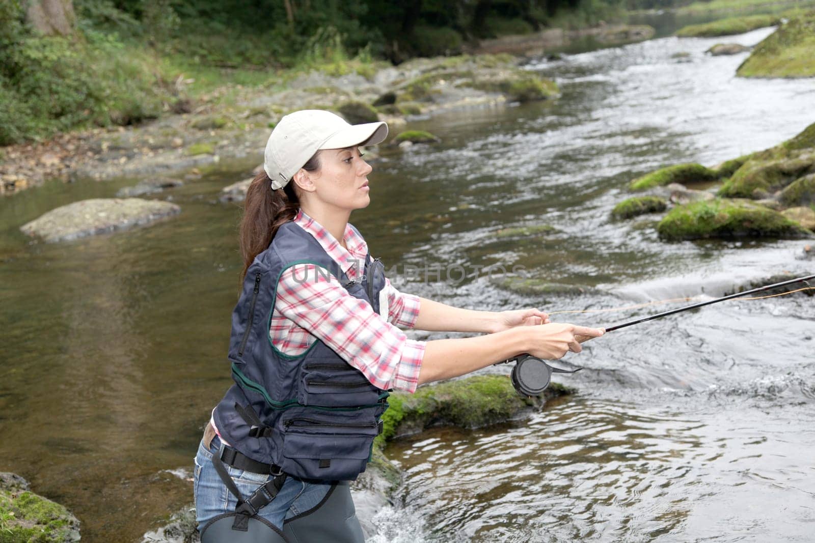 woman with fly fishing rod in river