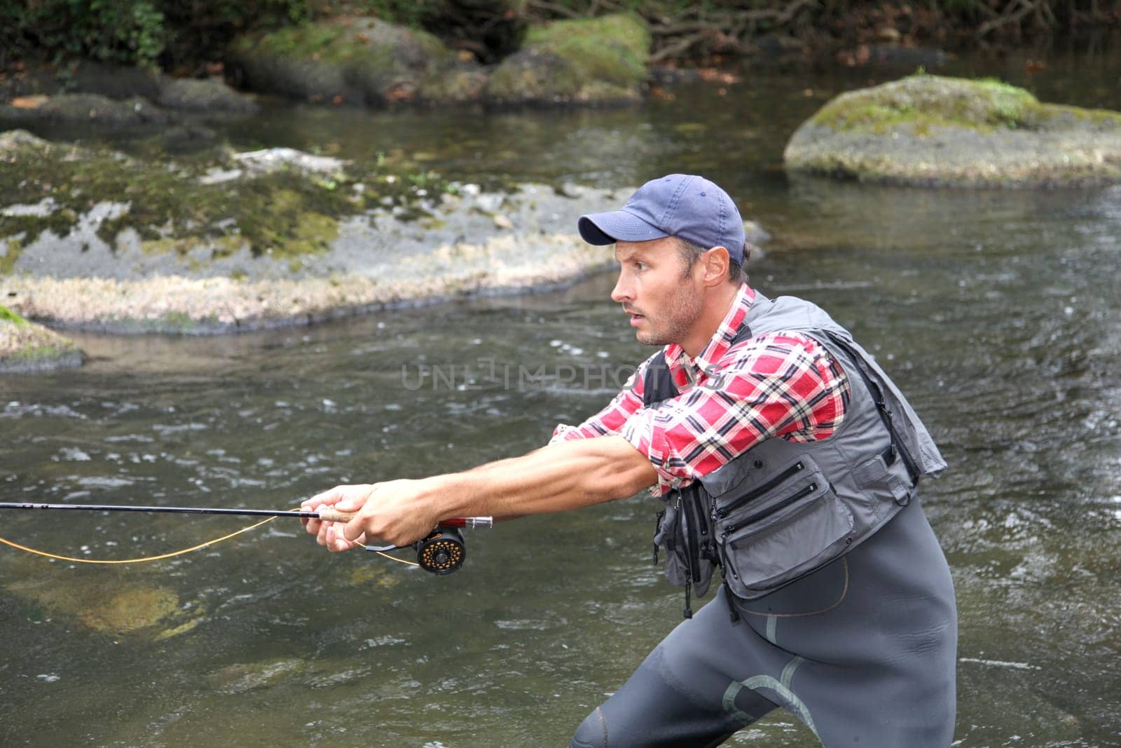 Fisherman in river with fly fishing line