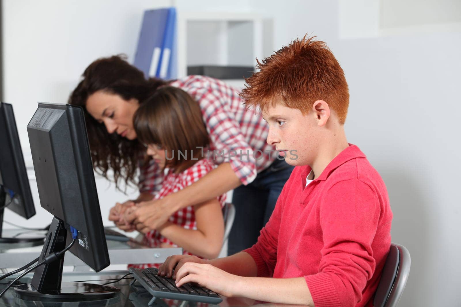 Teacher and children learning to use computer