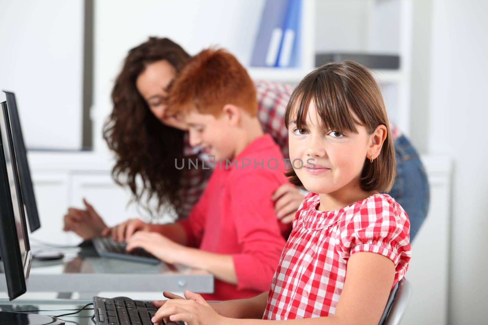 Teacher and children learning to use computer