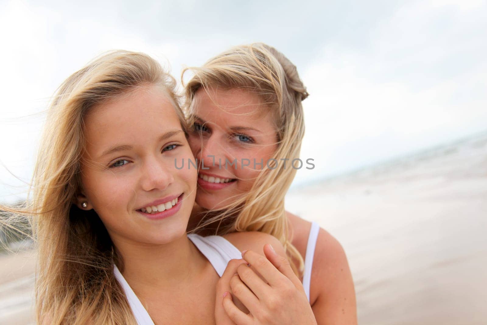 Blond woman and young girl on a sandy beach