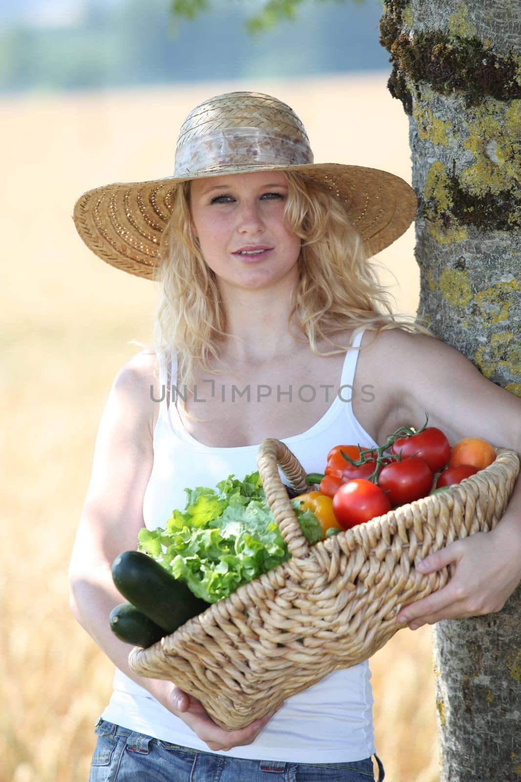 Beautiful woman holding basket of fresh vegetables