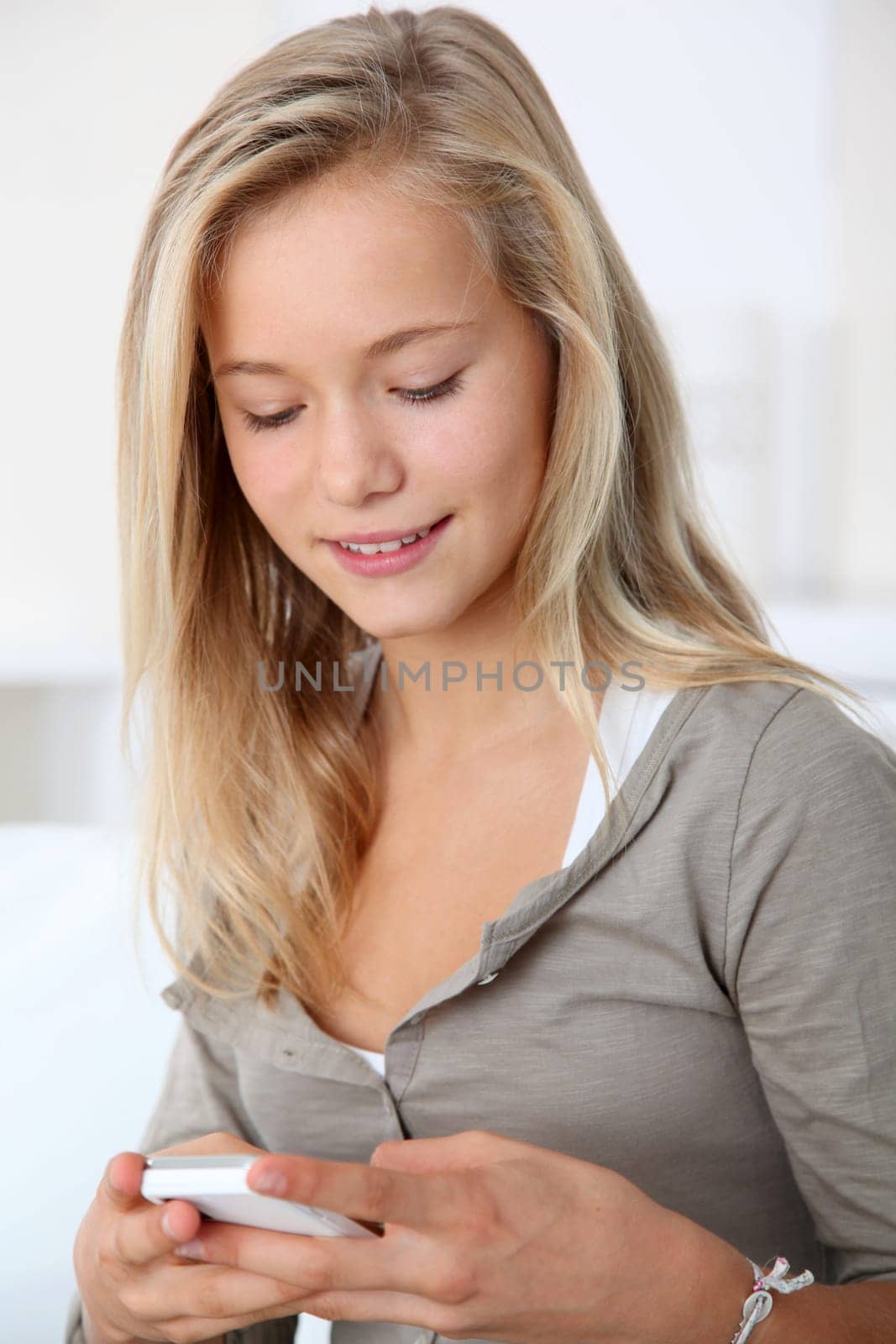 Closeup of beautiful blond girl with mobile phone