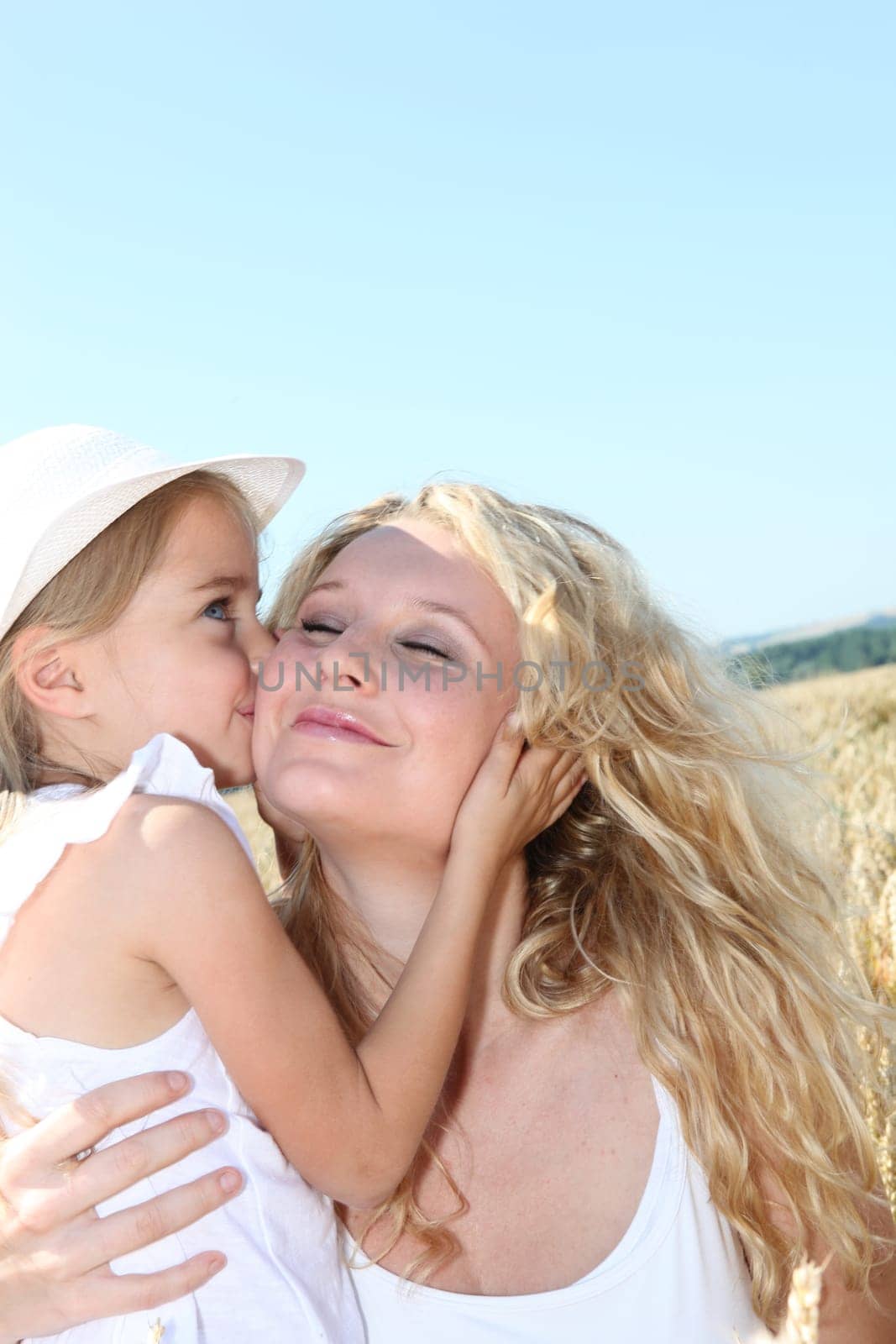 Little girl kissing her mom on the cheek