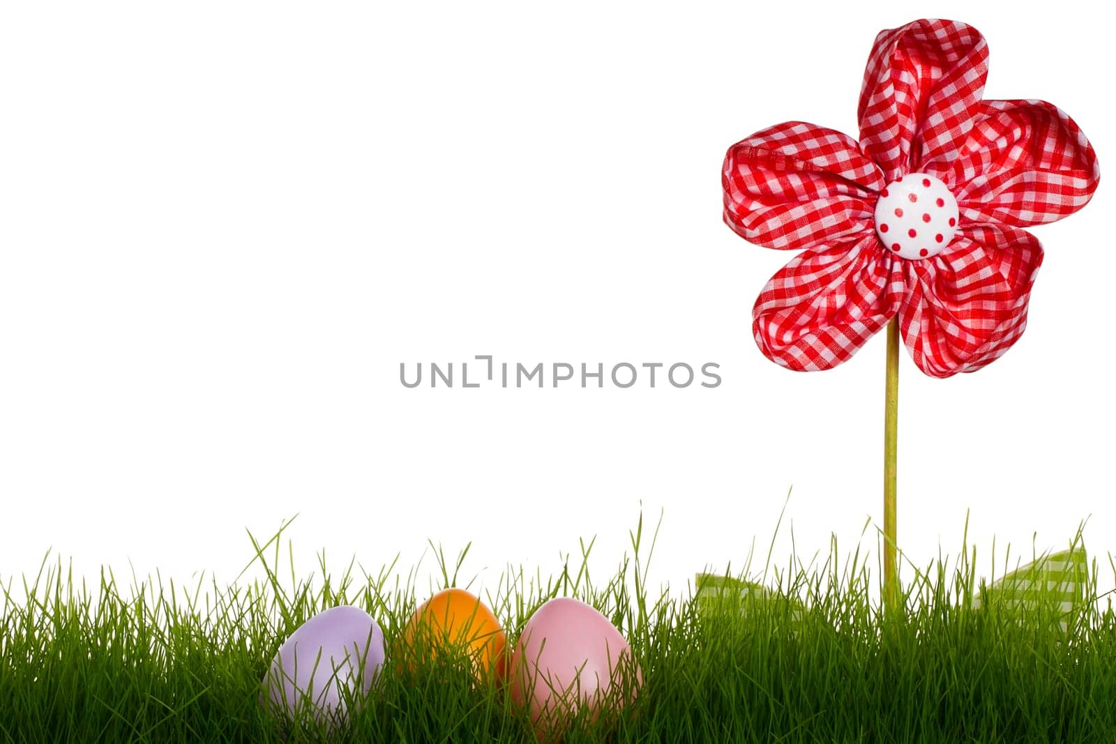 Three pastel-colored Easter eggs in grass with