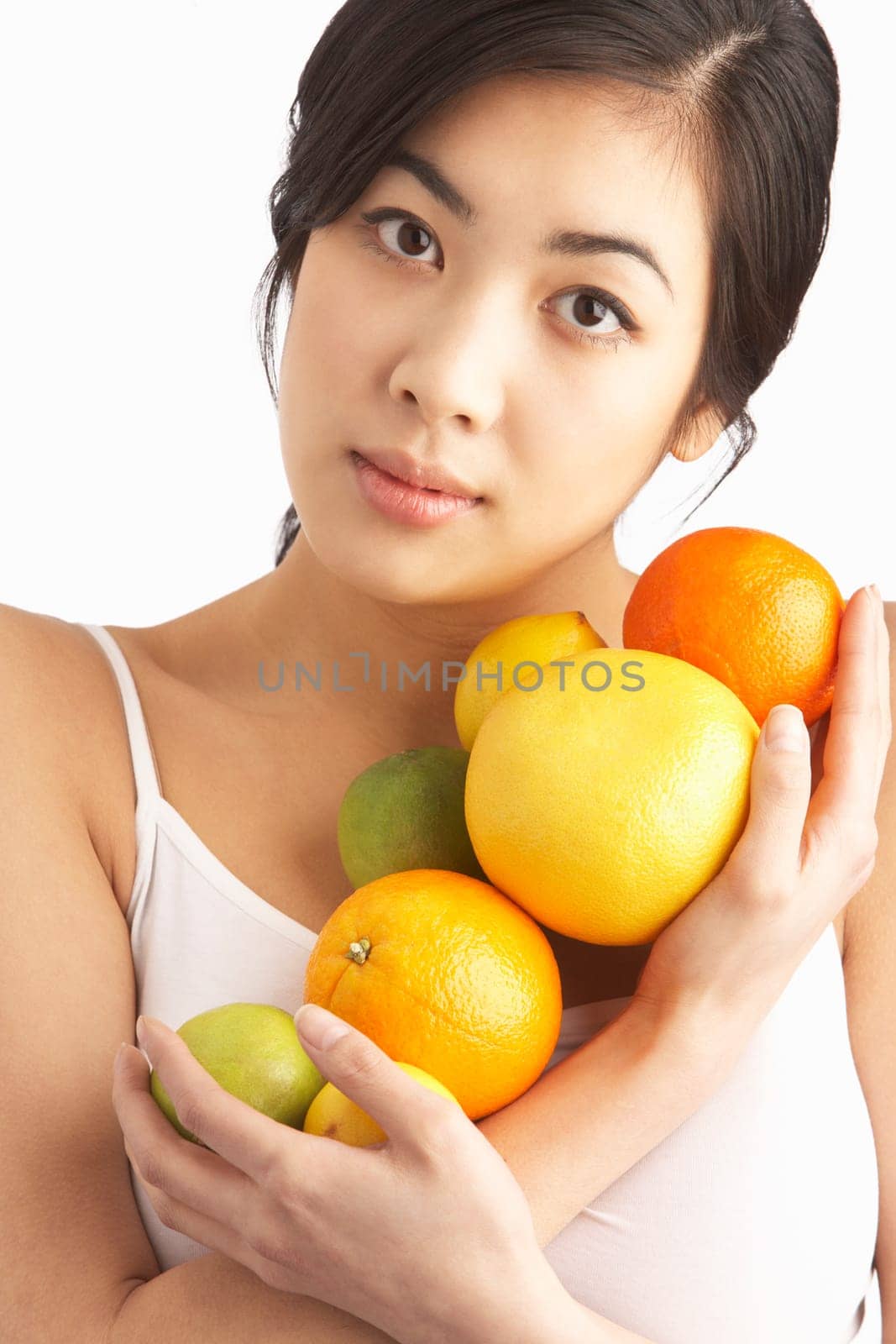 Young Woman Holding Citrus Fruit In Studio